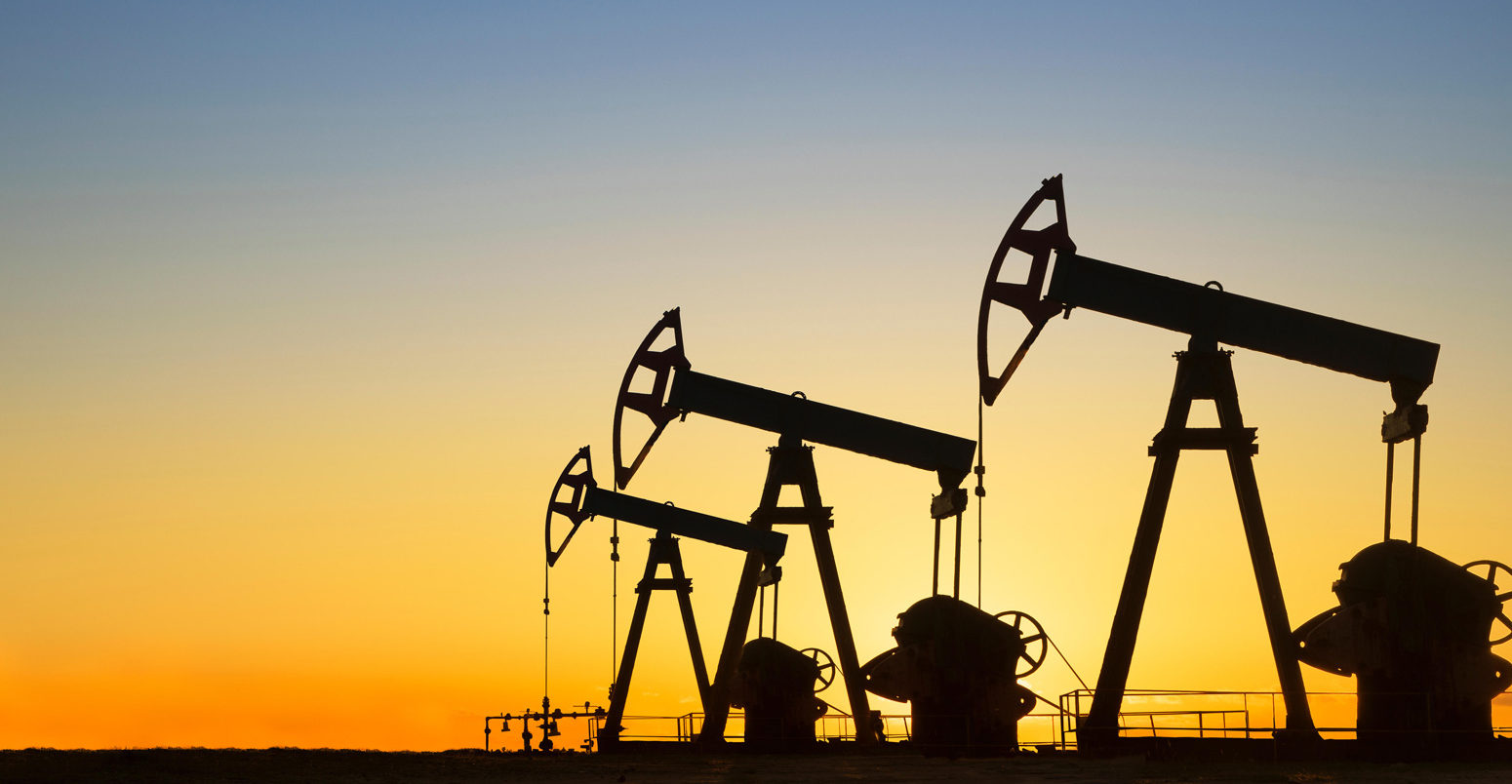 Silhouette of oil wells in desert at sunset, Texas, USA.