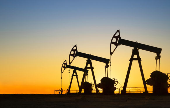 Silhouette of oil wells in desert at sunset, Texas, USA.