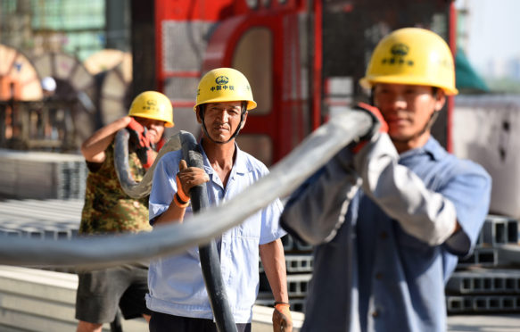 Chinese migrant workers of CREC labor at the construction site of the Huai'an East Railway Station for high-speed railway.