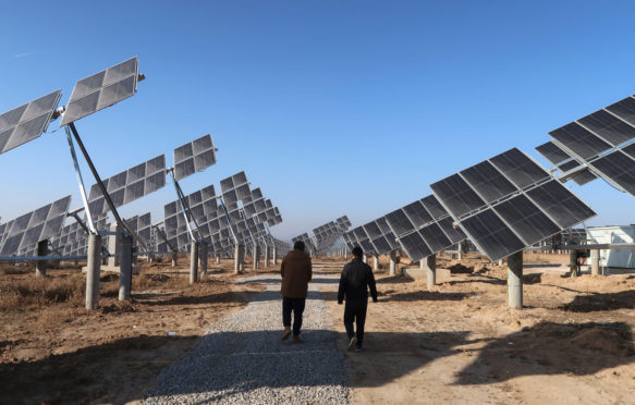 Workers walk at a solar power station in Tongchuan, Shaanxi province, China December 11, 2019. Picture taken December 11, 2019. Credit: REUTERS/Sean Yong
