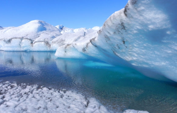 Melting ice in Greenland - ice cave with blue water on inland ice sheet.