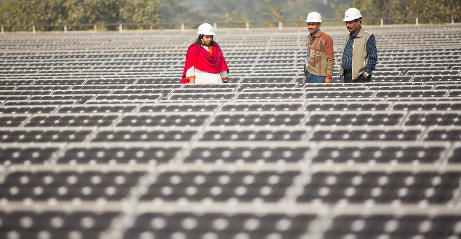 Workers-at-a-1MW-solar-power-station-run-by-Tata-Power-on-the-roof-of-an-electricity-company-in-Delhi,-India