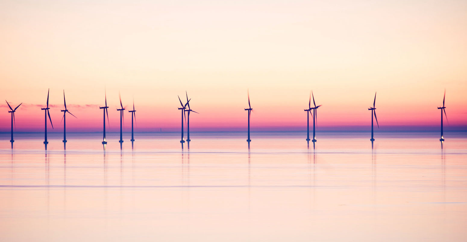 Wind power stations at sea in evening