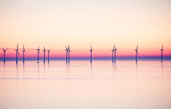 Wind power stations at sea in evening