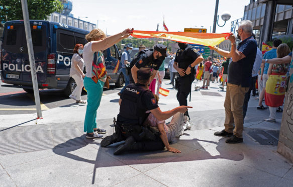 A protester falls unconscious under the high temperatures and is attended to by police during the protest