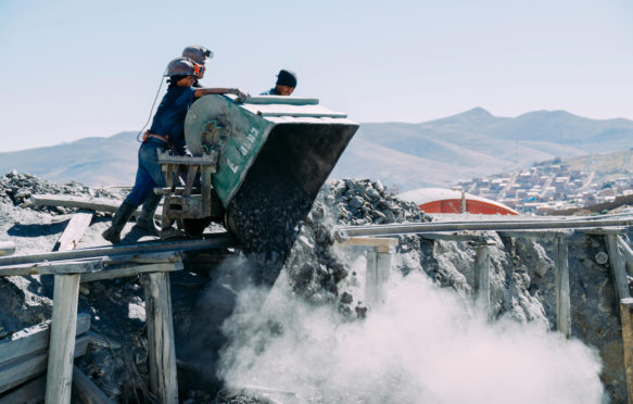 Workers dumping coal at a construction site