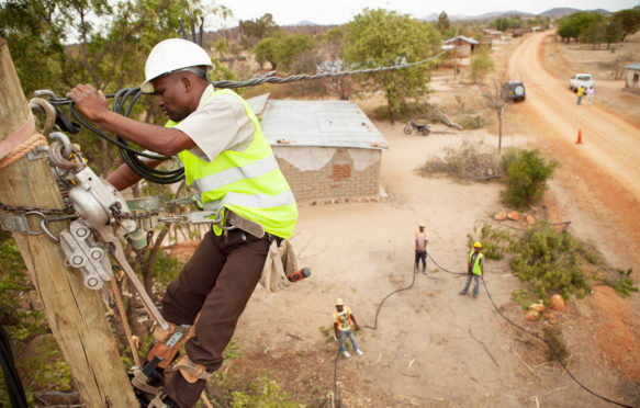 Workers-string-new-power-cables-in-a-rural-village-near-Dodoma,-Tanzania,-East-Africa-Image ID: FA4P68