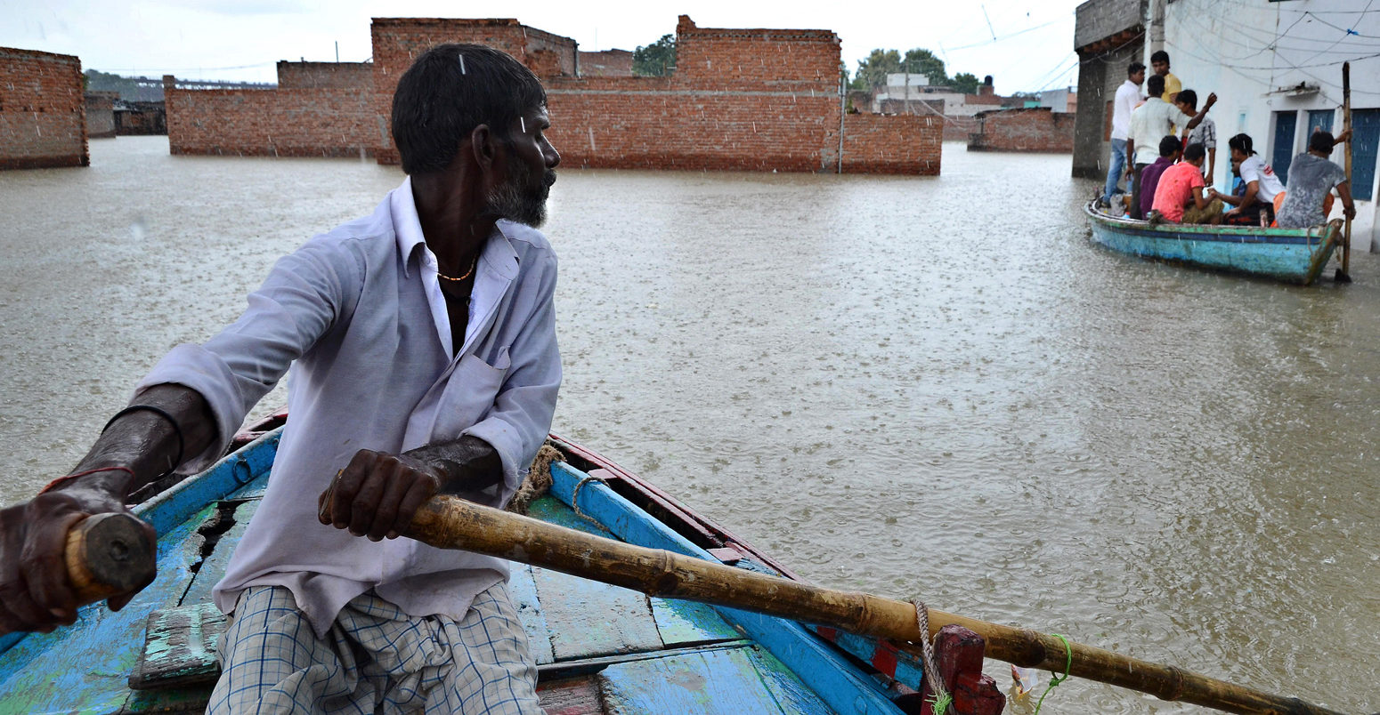A man paddles a boat in the flooded village of Varanasi, India