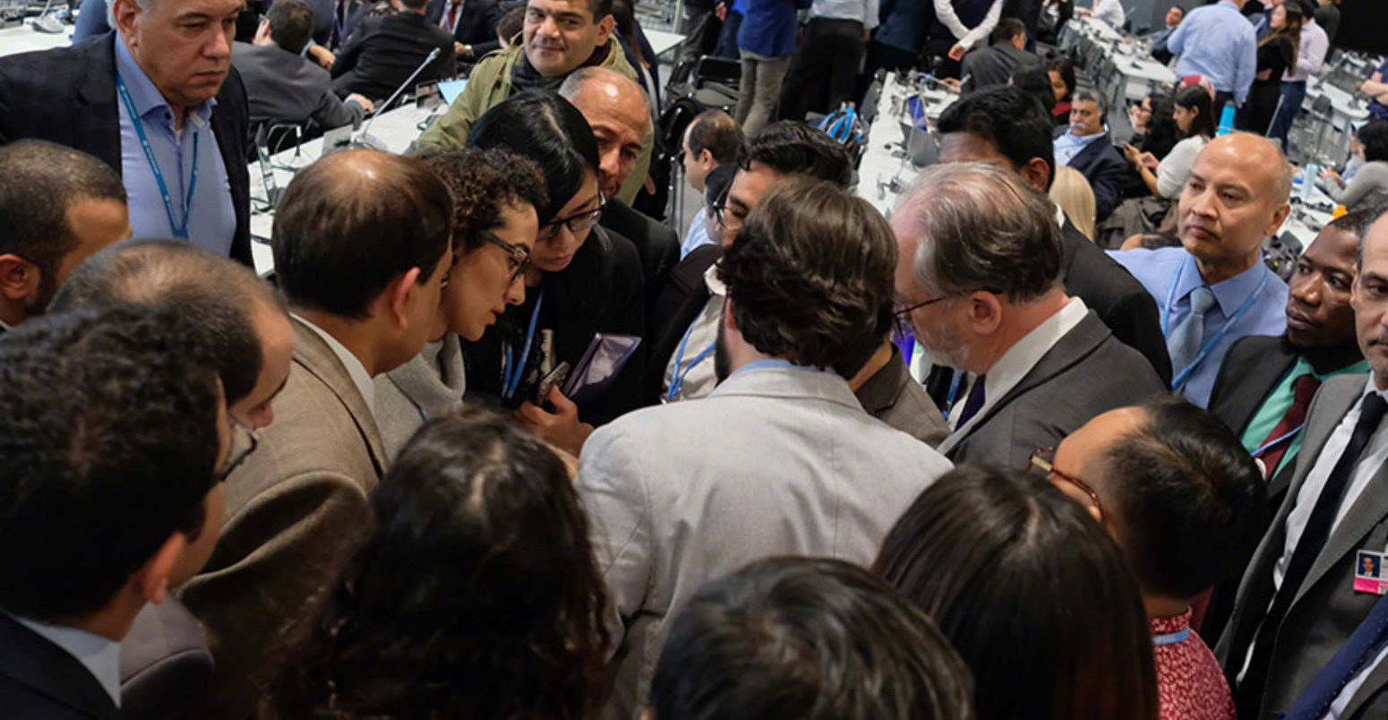 Delegates huddle during the final stages of the SBSTA closing plenary at COP25