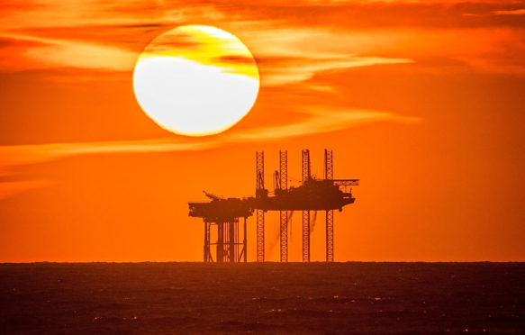 Sunset pours into the horizon behind the Hamilton Oil Rig off the Southport coastline, UK