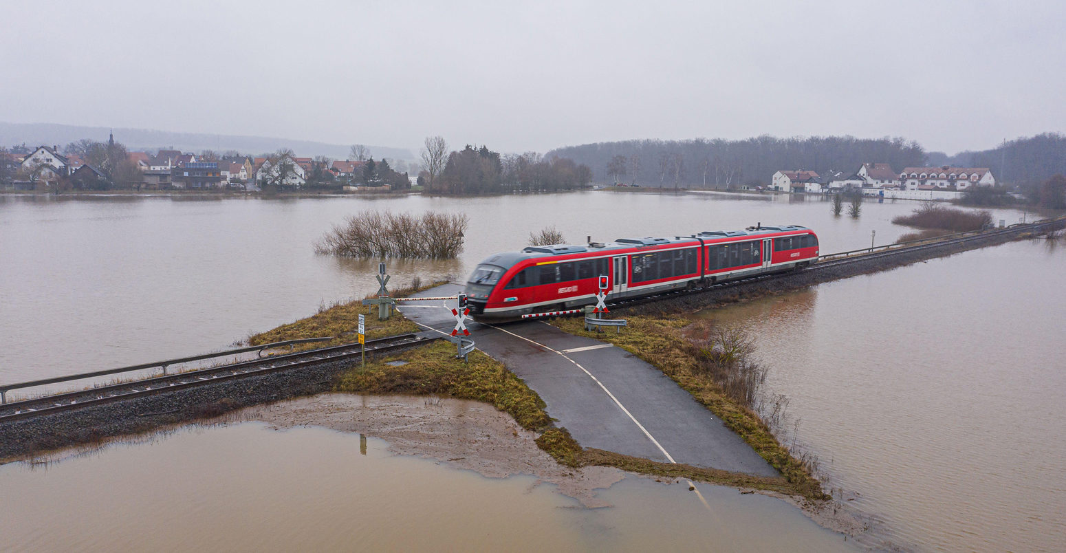 Train-passing-through-a-flooded-road-in-Germany,-February-2021