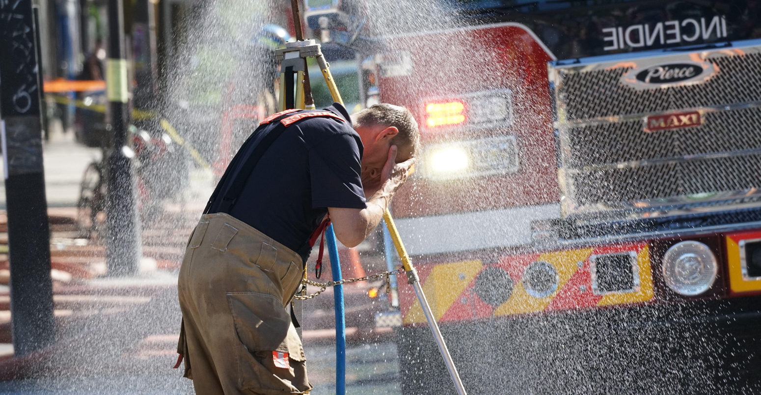 Fireman cooling off after battling a fire in hot weather in Montreal, Canada June 2021