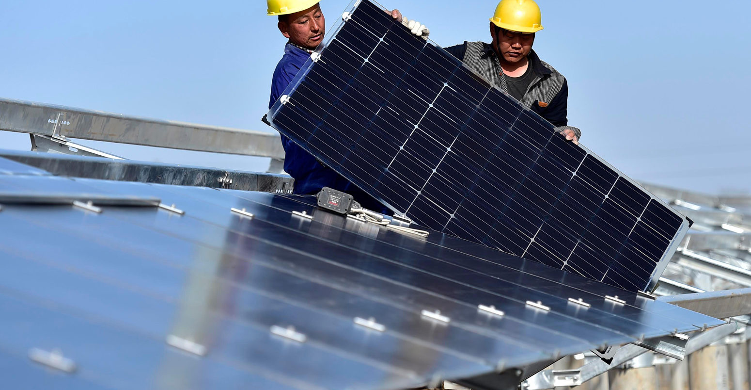 Staff-install-solar-panels-at-Xinyi-Photovoltaic-Power-Plant-in-Binhai-District-of-Tianjin,-North-China