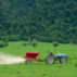 Farmer spraying fertiliser on a field for sheep grazing in New Zealand