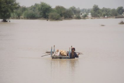 A woman carries her belongings through flood water in Rajanpur, Pakistan in August, 2022