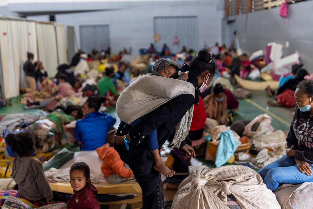 A woman carries a child as locals who were displaced from Cyclone Ana find refuge in an evacuation centre at the neighbourhood of West Ankorondrano, Madagagascar, 5 February 2022.