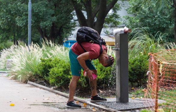 A young man refreshes himself at Giordano Bruno Square, City of Buenos Aires, during the January 2022 heat wave in Argentina.