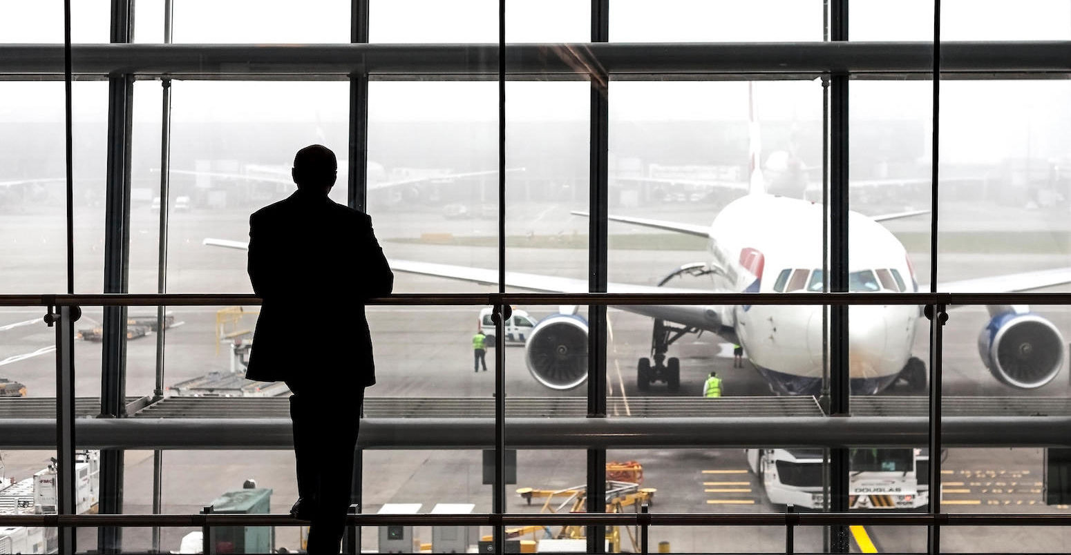 Silhouette of a passenger waiting for a plane at Heathrow airport, London, UK.
