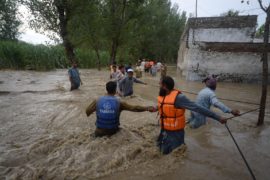 Citizens make their way through flooded streets with difficulty in the Dagai Mukaram Khan region, Pakistan.