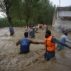 Citizens make their way through flooded streets with difficulty in the Dagai Mukaram Khan region, Pakistan.