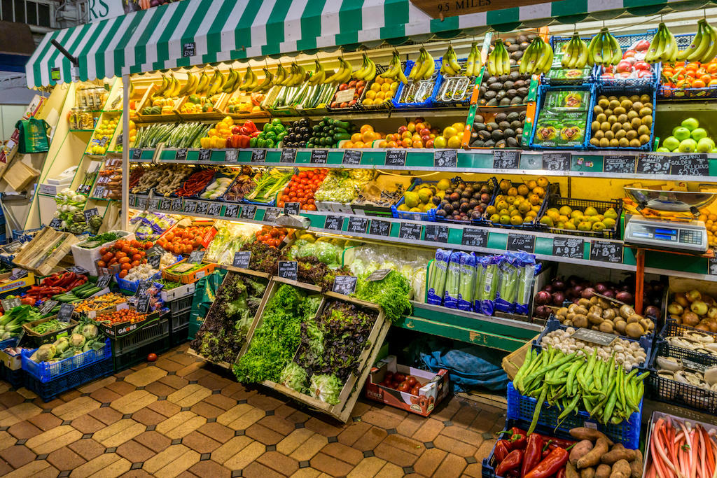 Fruits & vegetables for sale on a stall in a covered market in Oxford.