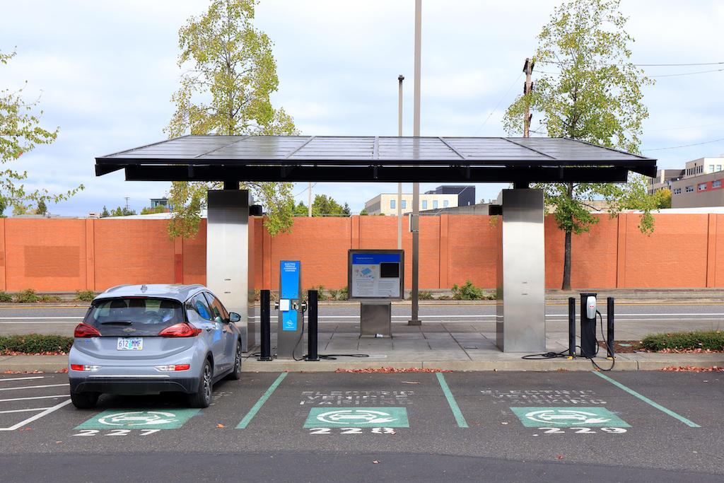 A solar canopy electric vehicle charging station with ebike shower charging lockers.