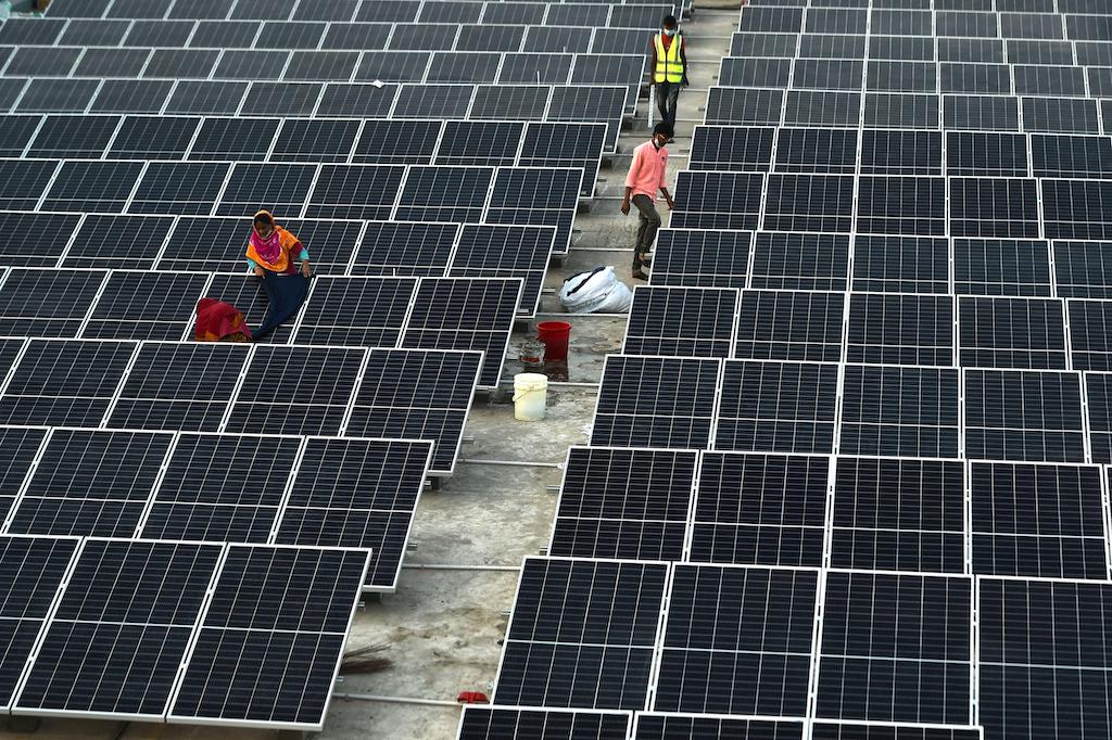 Technicians install solar panels on a factory towers in Gazipur on the outskirts of wanted Dhaka, Bangladesh on Jan. 3, 2021.