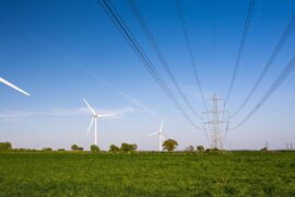 Wind turbines beside national grid high voltage power lines in Gloucestershire.