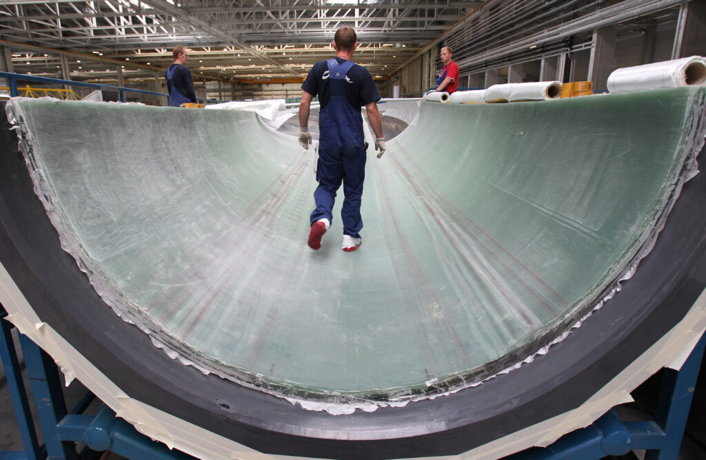 Work is being done on a 45-meter-long rotor blade at the factory grounds of wind turbine manufacturer Nordex in Rostock, Germany, 06 August 2010.