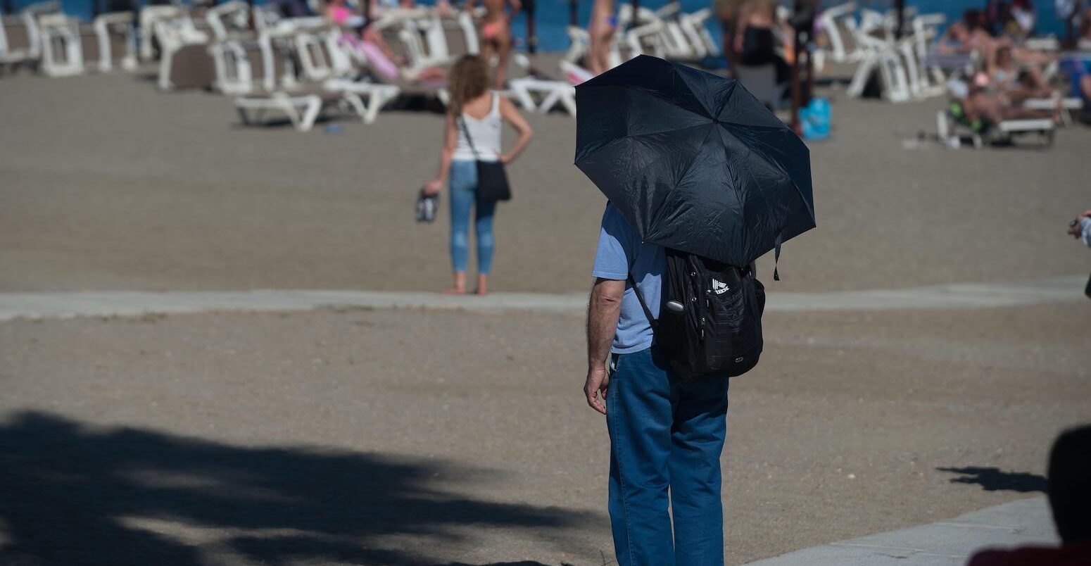 A man is seen at a near-empty 'La Malagueta beach' during an unusual heat wave on 26 April 2023.