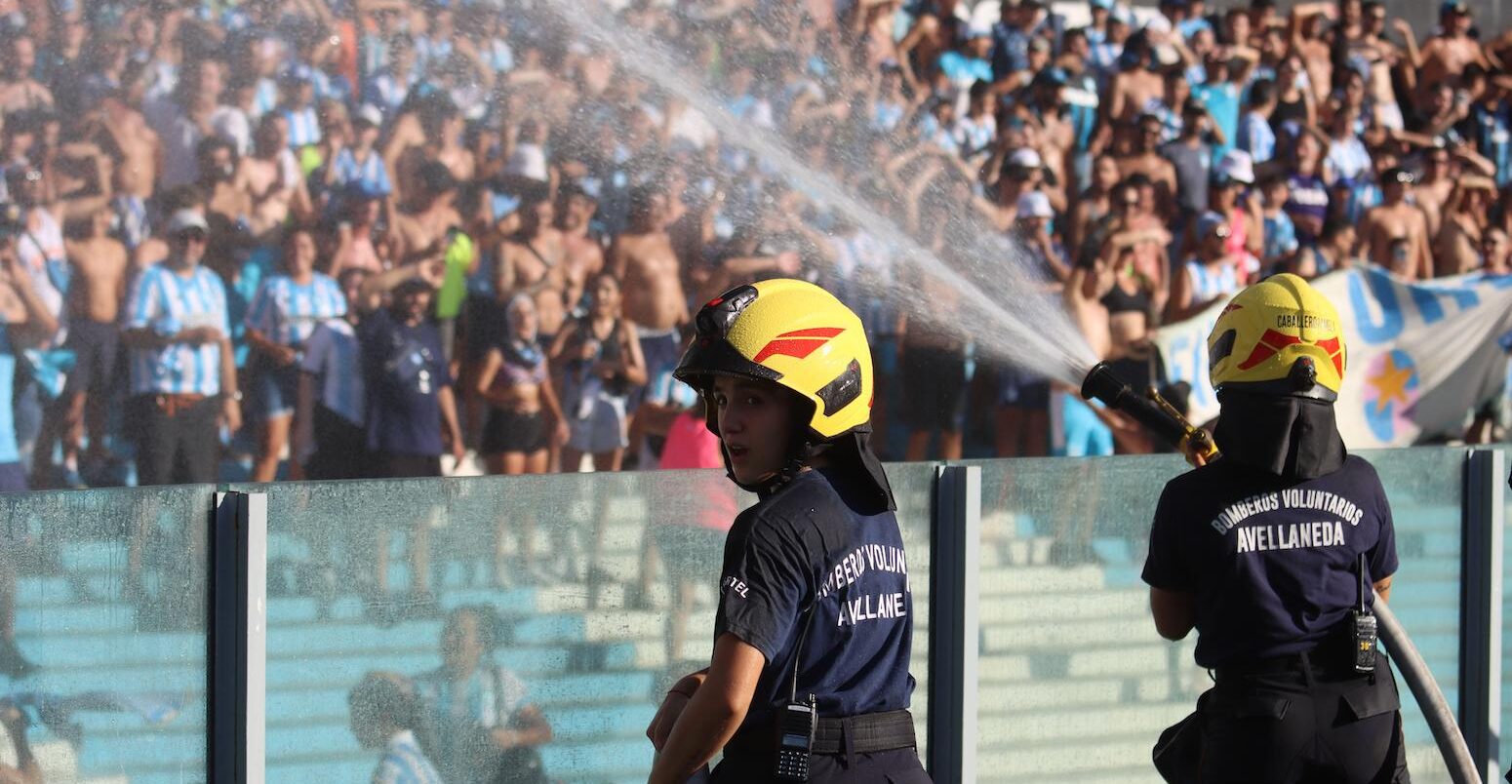 Firefighters spray water at people due to intense heat during a football game in Argentina.