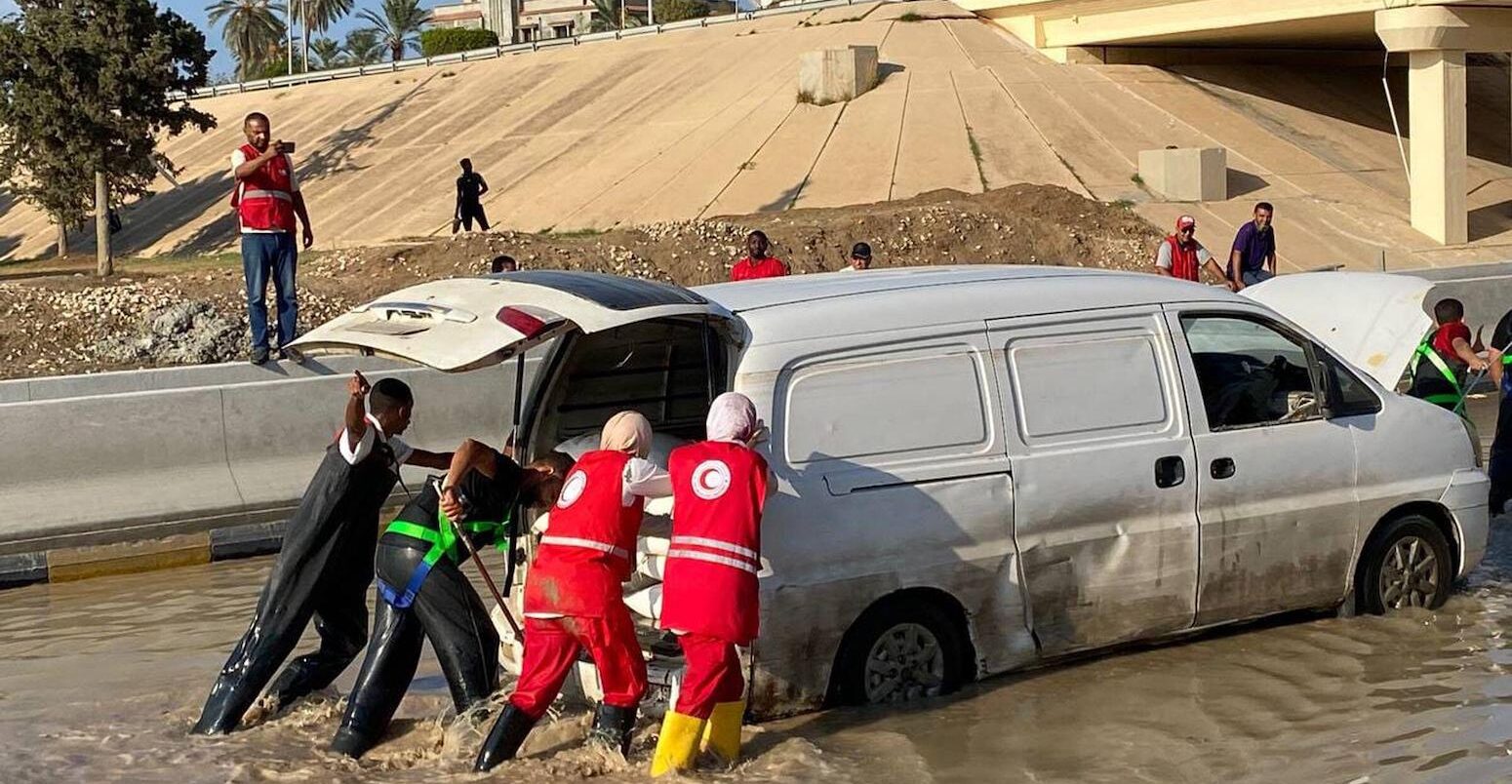 Libyan Red Crescent members work on opening roads engulfed in floods.