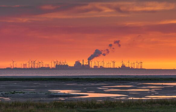 The Wadden Sea, factory buildings and wind turbines at sunset, Eemshaven, Netherlands.