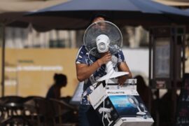 A man carries a fan as temperatures reach 38C in Montpellier, France.