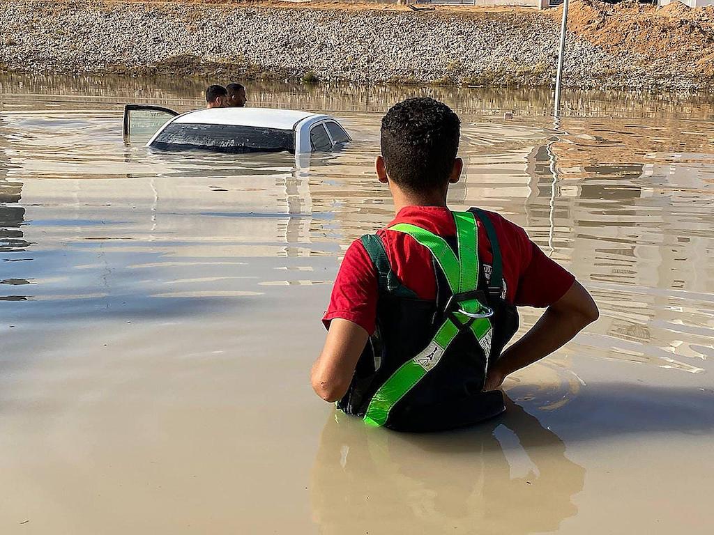 Libyan Red Crescent members work on opening roads engulfed in floods.