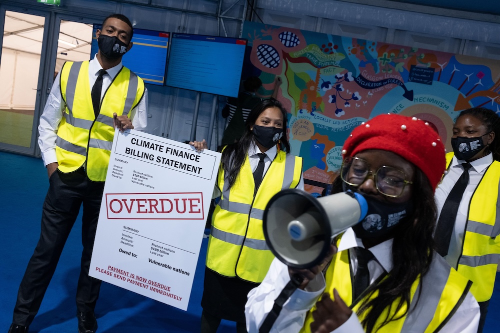 Protestors inside the COP26 conference venue in Glasgow, Scotland draw attention to failures to deliver on climate finance, 2021.