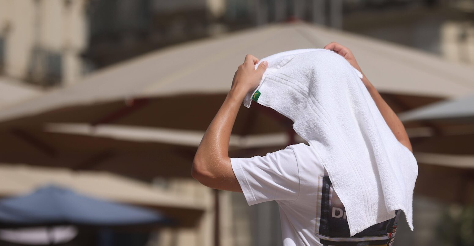 A person covers themselves with a towel as temperatures reach 38C in Montpellier, France on 19 July 2023.