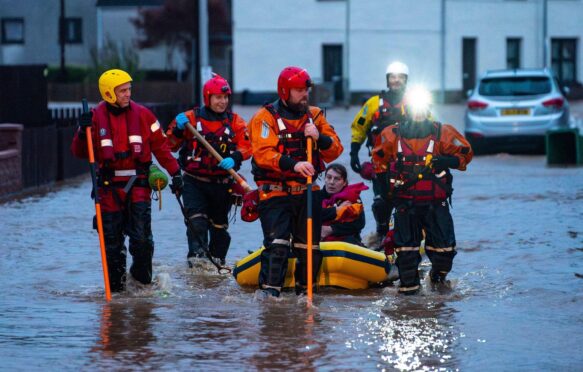 Rescue workers escort residents to safety after heavy rainfall in Brechin, Scotland on 20 October 2023.