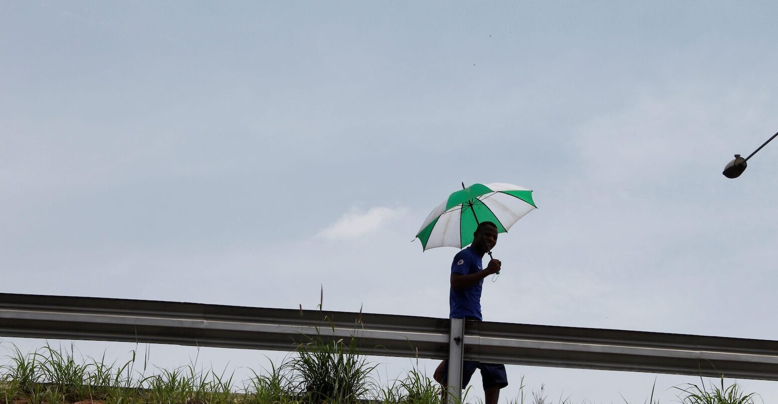 A man walking with an umbrella in hand, Lagos, Nigeria.