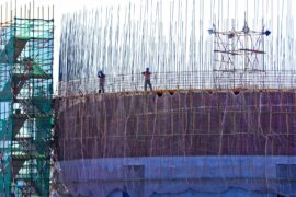 Builders bundle steel frames at a coal construction site in Gansu, China.