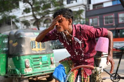 A rickshaw driver washing his face with water during a hot day in Dhaka, Bangladesh, on 15 April 2024.