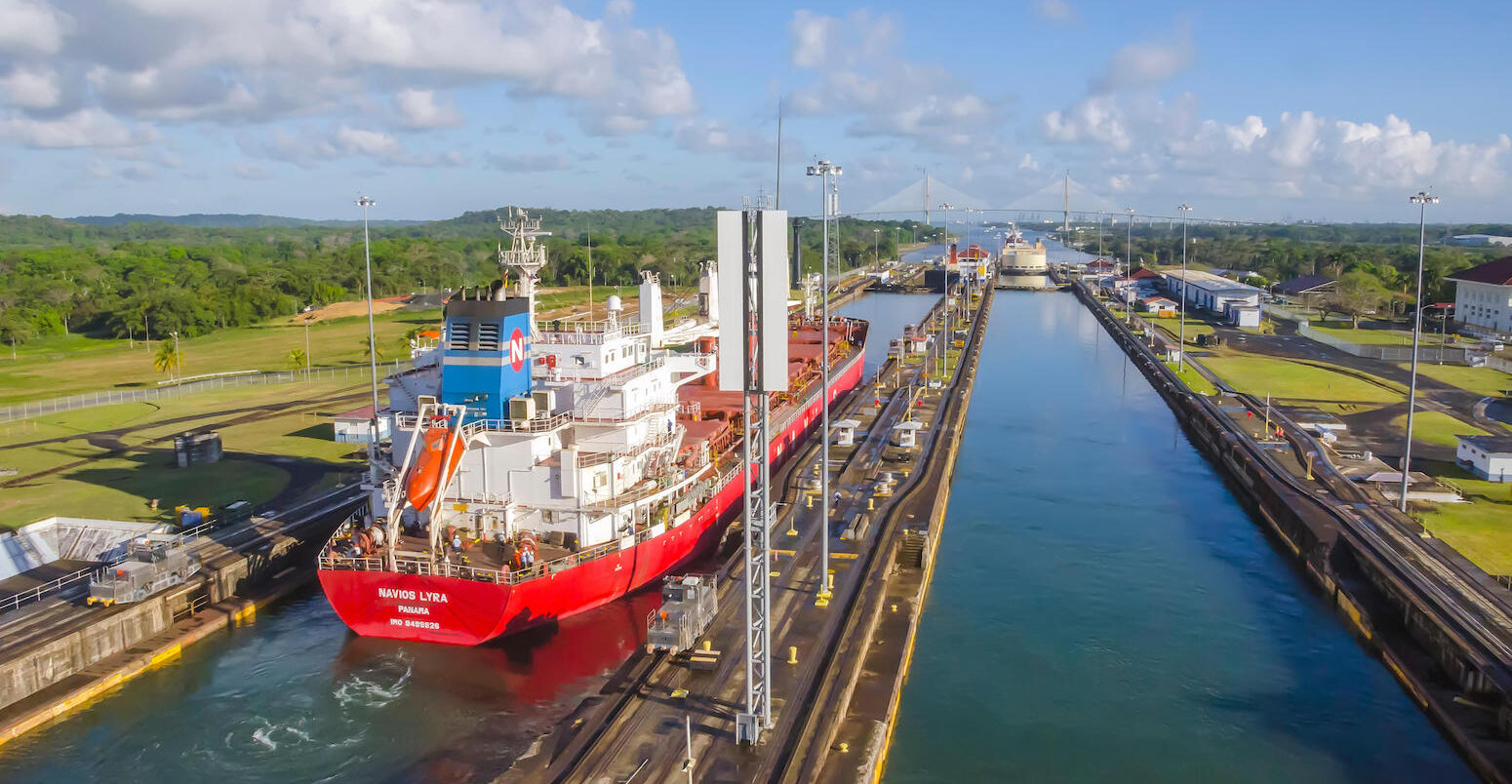 Red cargo ship transits through Gatun Locks, Panama Canal.