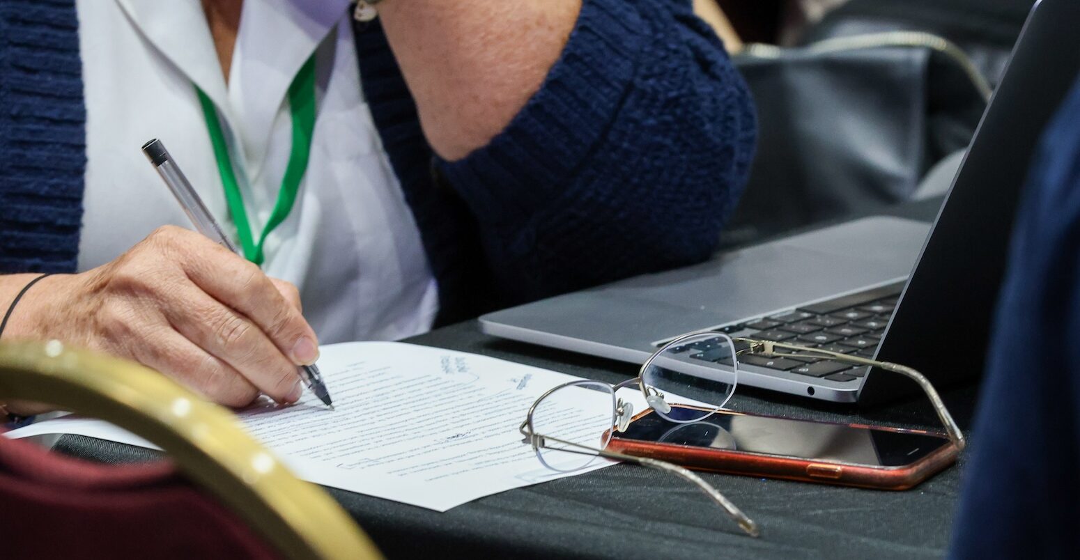 A person writes on paper.