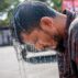 A man bends over during a summer heatwave in Bangladesh.