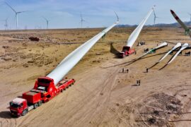 Builders transfer wind turbine blades to a hoisting site at the construction site in Zhangye, China.