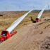 Builders transfer wind turbine blades to a hoisting site at the construction site in Zhangye, China.