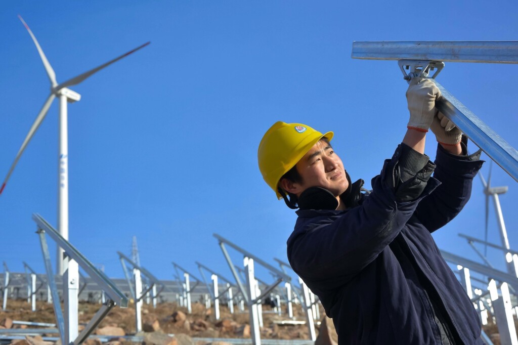 A worker installs solar panels at a photovoltaic power station in Luoyang city, China.
