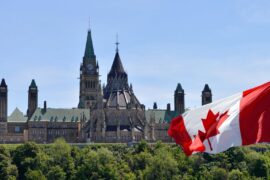 Canadian parliament buildings and Canada flag. Credit: Colin Clarke / Alamy Stock Photo. Image ID: WB161K.