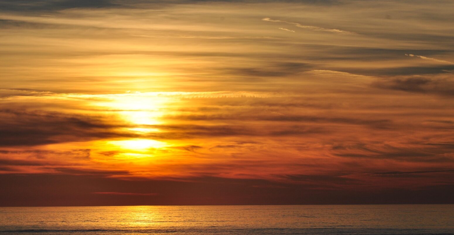 Red sky sun-setting and atmospheric clouds over the sea at Aberystwyth.