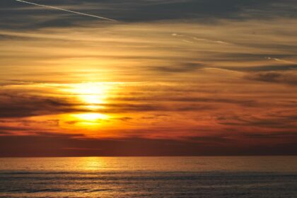 Red sky sun-setting and atmospheric clouds over the sea at Aberystwyth.